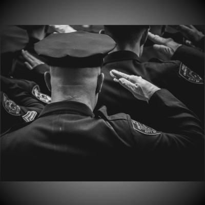 Uniformed law enforcement officers saluting